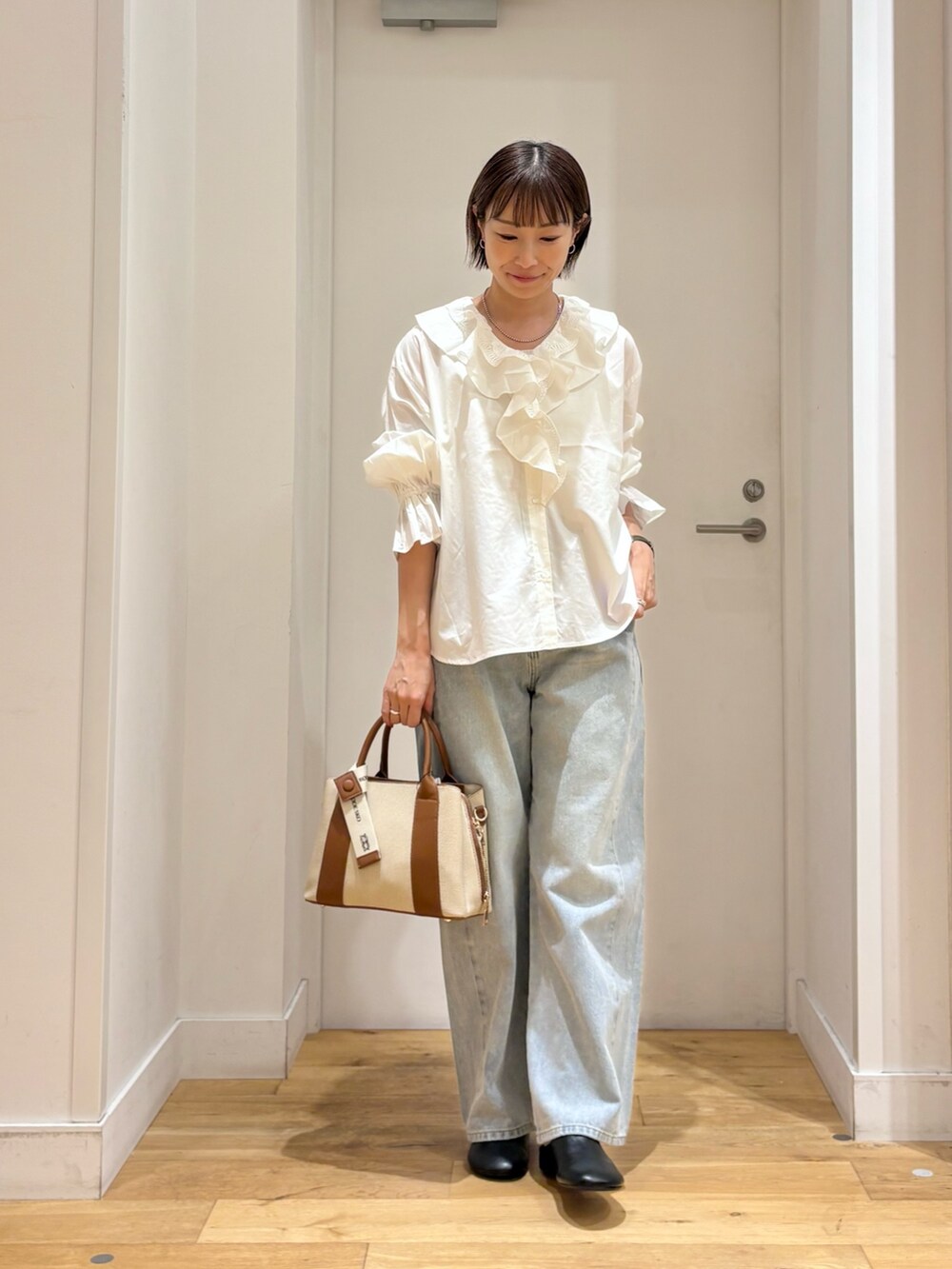 ホワイト系のシャツ/ブラウス、ブルー系のデニムパンツ、ブラック系のその他シューズを着用したレディースの秋コーディネートの3枚目の写真