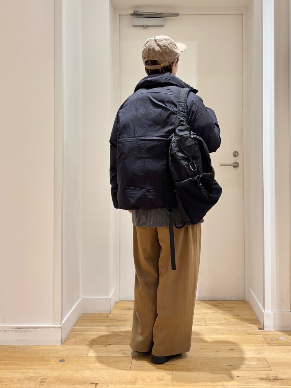 ベージュ系のその他パンツ、グレー系のニット/セーター、ブラック系のダウンジャケット/コートを着用したレディースの秋コーディネートの5枚目の写真