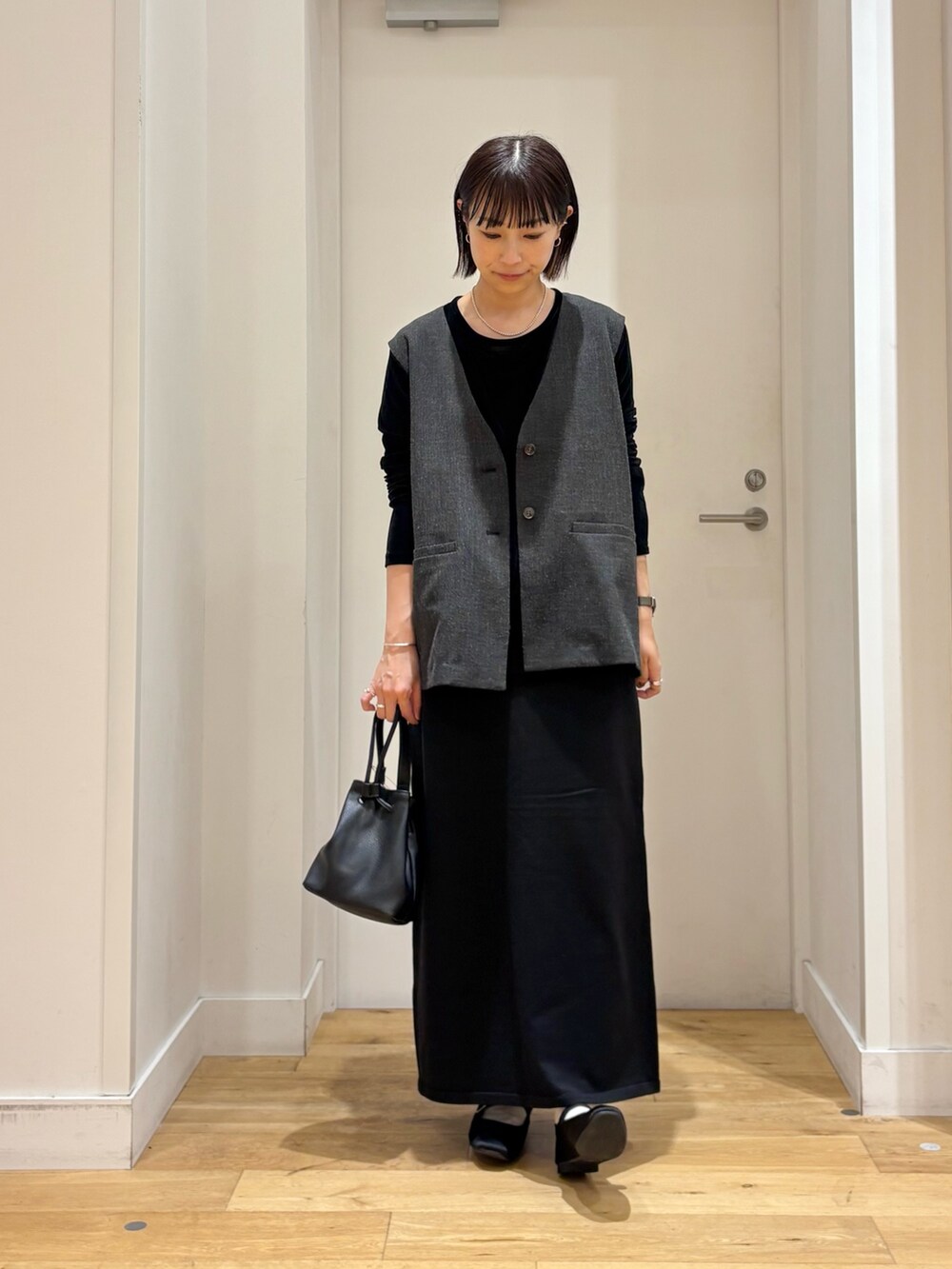 ブラック系のショルダーバッグ、ブラック系のTシャツ/カットソー、ブラック系のその他アウターを着用したレディースの秋コーディネートの4枚目の写真