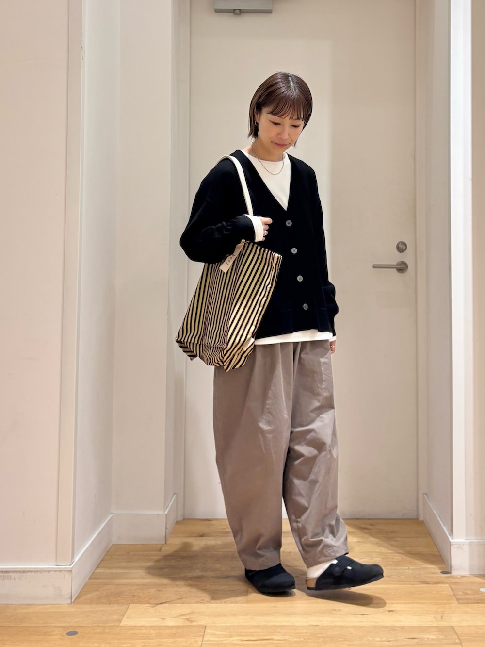 ブラック系のカーディガン/ボレロ、ホワイト系のTシャツ/カットソー、ブラック系のその他シューズを着用したレディースの秋コーディネートの5枚目の写真