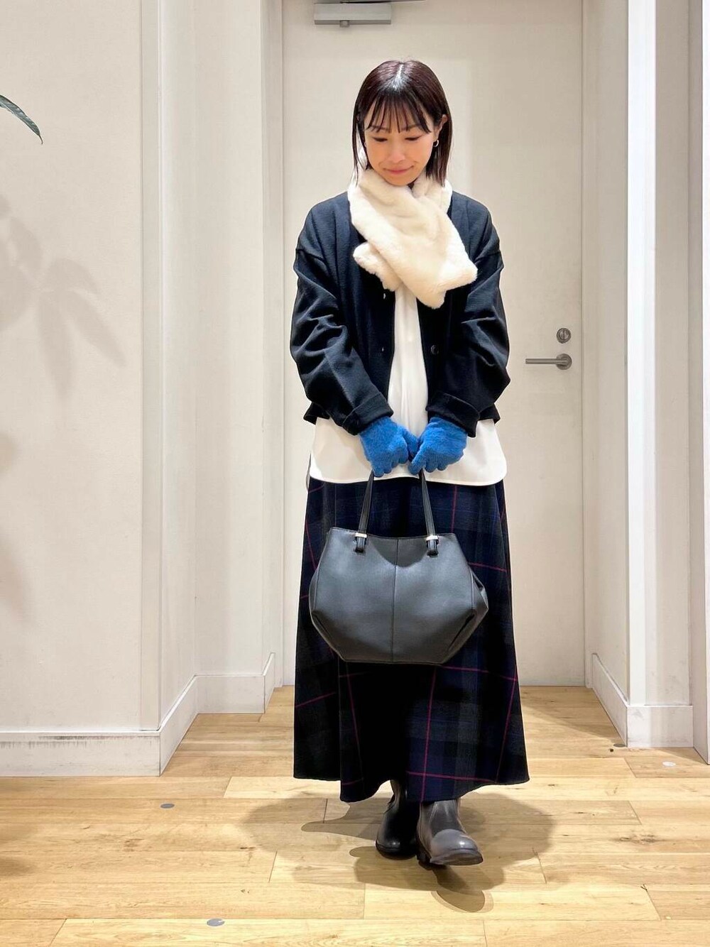 ブラック系のショルダーバッグ、グレー系のブーツ、ブラック系のカーディガン/ボレロを着用したレディースの秋コーディネートの2枚目の写真