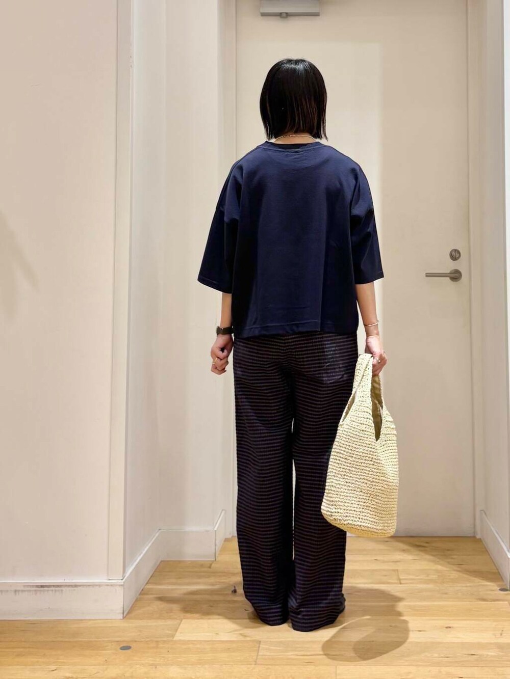 ベージュ系のトートバッグ、グレー系のサンダル、ブルー系のTシャツ/カットソーを着用したレディースの夏コーディネートの5枚目の写真