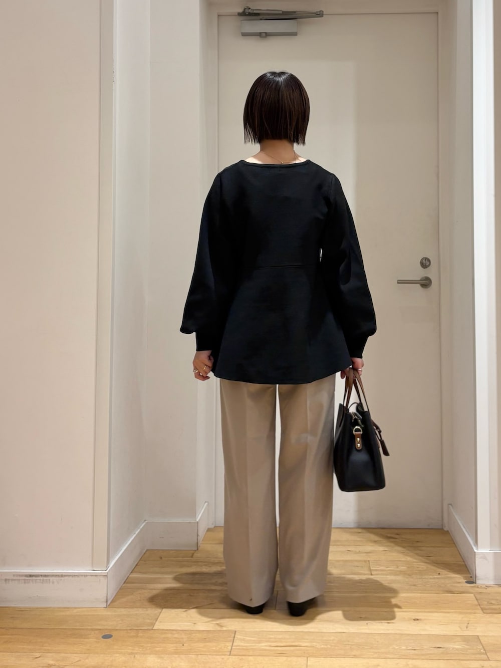 ブラック系のニット/セーター、ベージュ系のその他パンツ、ブラック系のパンプスを着用したレディースの冬コーディネートの6枚目の写真