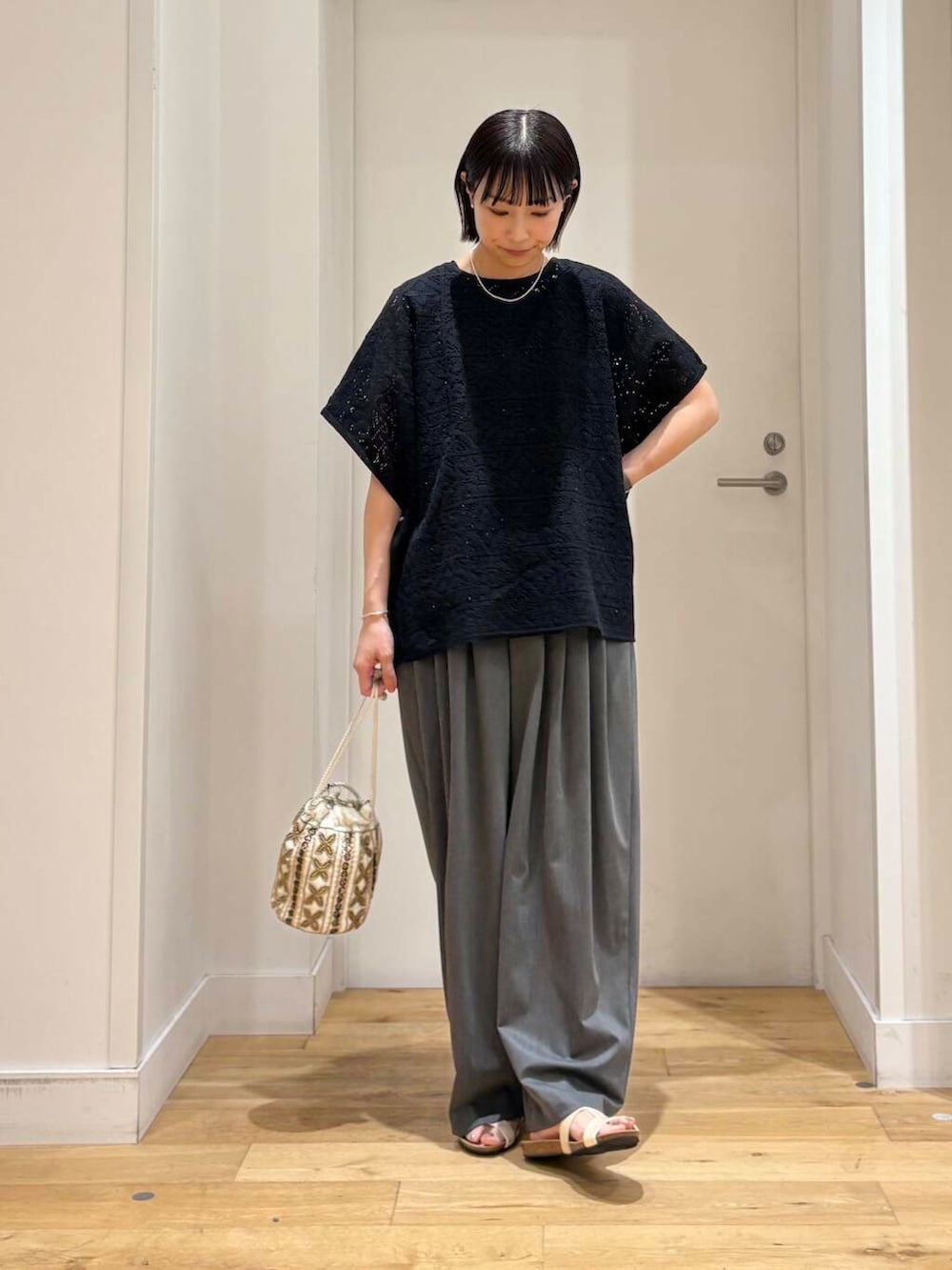 ホワイト系のショルダーバッグ、グレー系のその他パンツ、ホワイト系のサンダルを着用したレディースの夏コーディネートの3枚目の写真