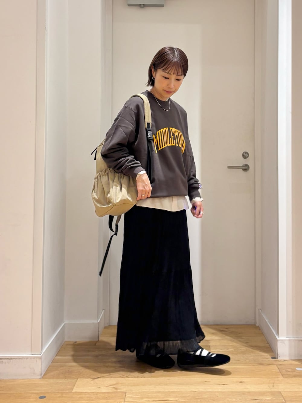 グレー系のスウェット、ブラック系のスカート、ベージュ系のシャツ/ブラウスを着用したレディースの秋コーディネートの5枚目の写真