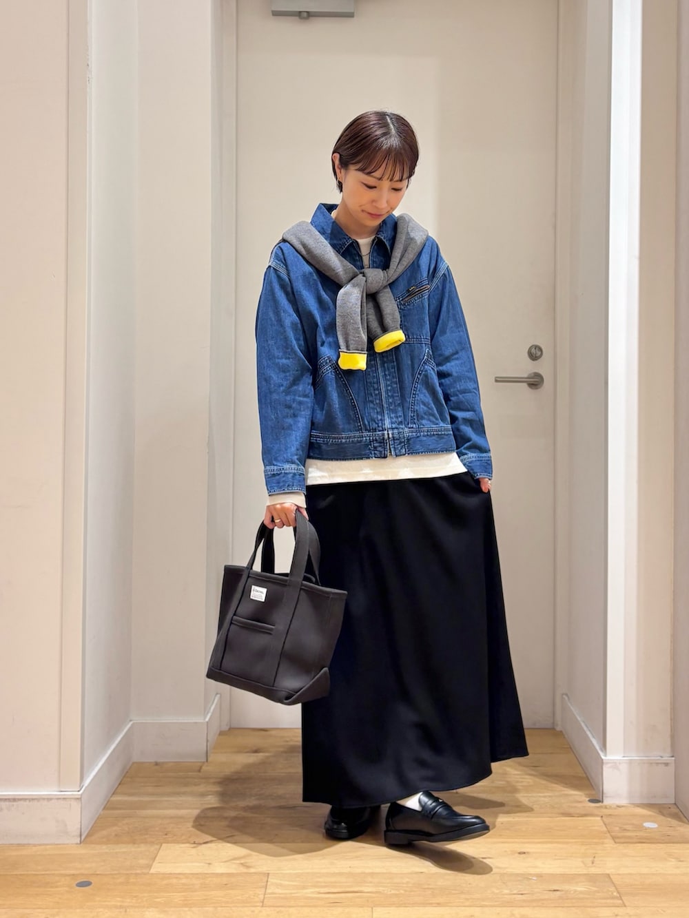 グレー系のカーディガン/ボレロ、ブルー系のデニムジャケット、ブラック系のローファーを着用したレディースの秋コーディネートの4枚目の写真