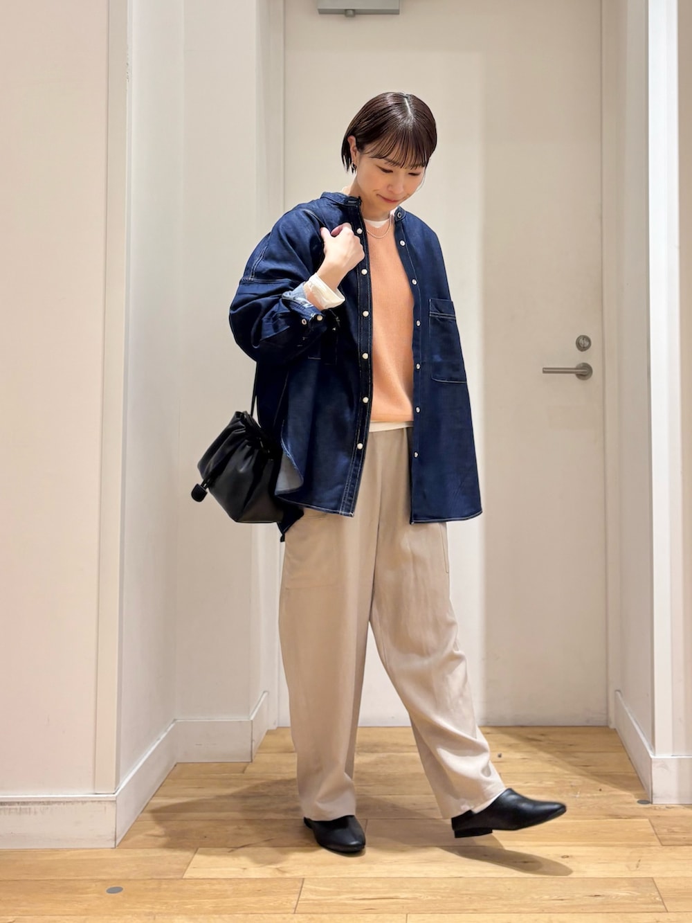 ブルー系のシャツ/ブラウス、ピンク系のニット/セーター、ホワイト系のTシャツ/カットソーを着用したレディースの春コーディネートの4枚目の写真