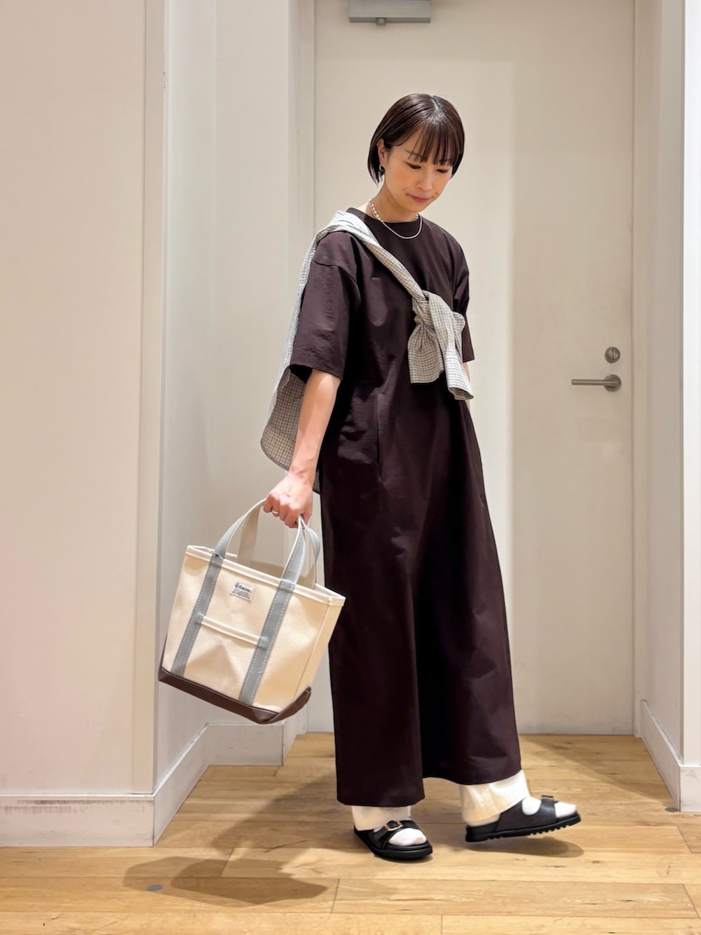 ブラウン系のワンピース、ブルー系のシャツ/ブラウス、グリーン系のトートバッグを着用したレディースの春コーディネートの5枚目の写真