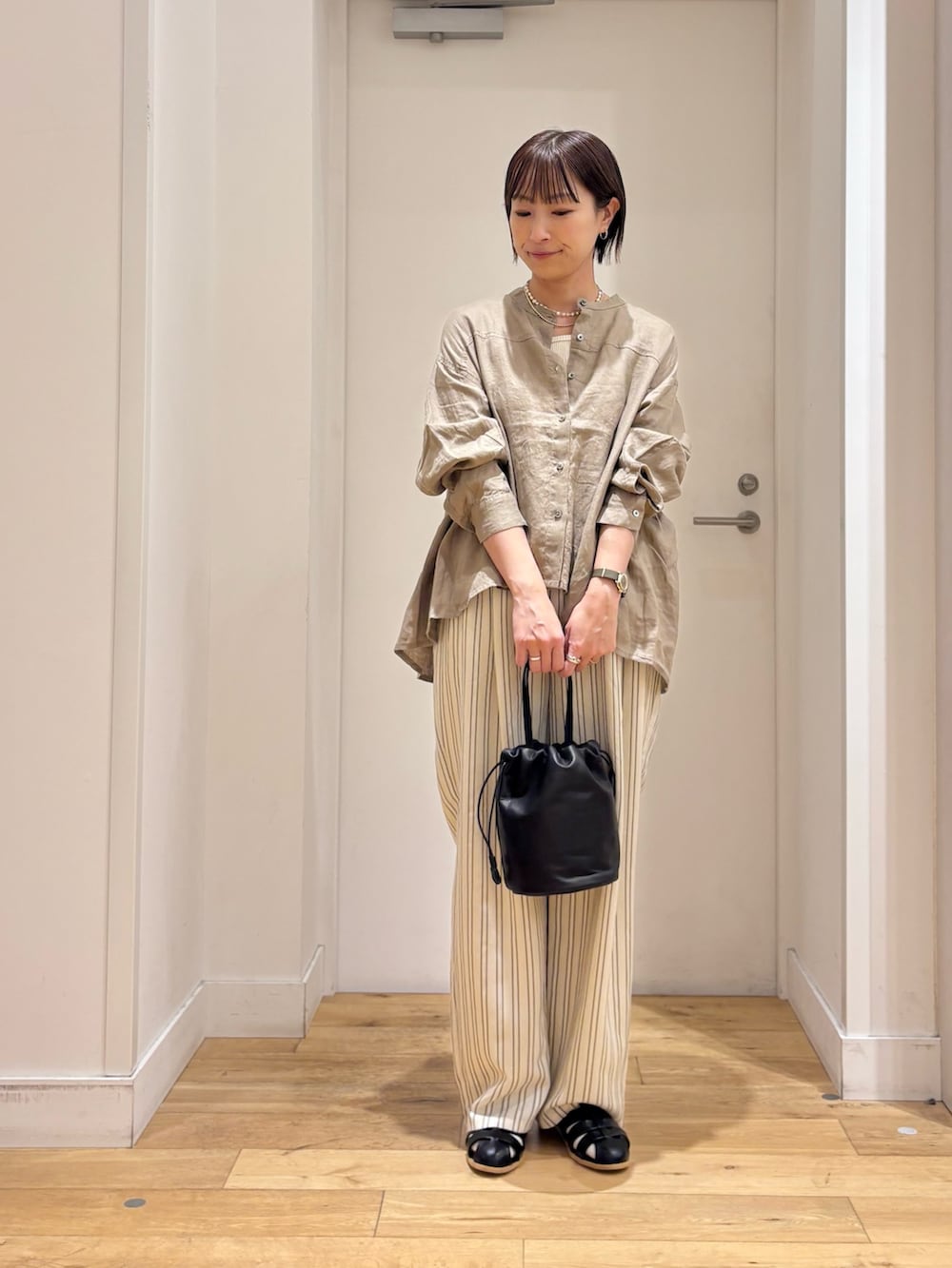 ブラウン系のシャツ/ブラウス、ホワイト系のタンクトップ、ベージュ系のその他パンツを着用したレディースの春コーディネートの4枚目の写真