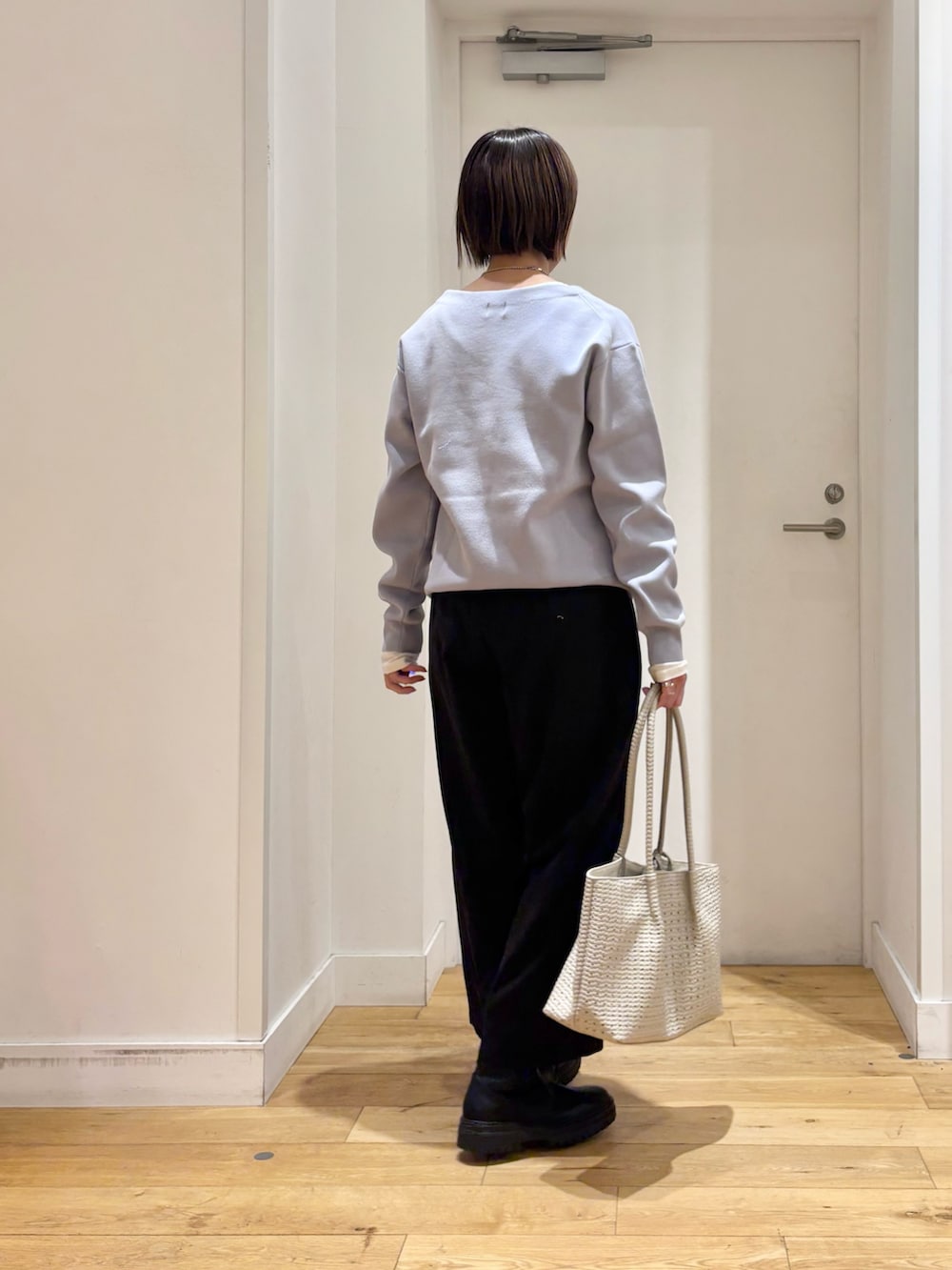 ブラック系のその他パンツ、ホワイト系のトートバッグ、ブラック系のブーツを着用したレディースの冬コーディネートの6枚目の写真