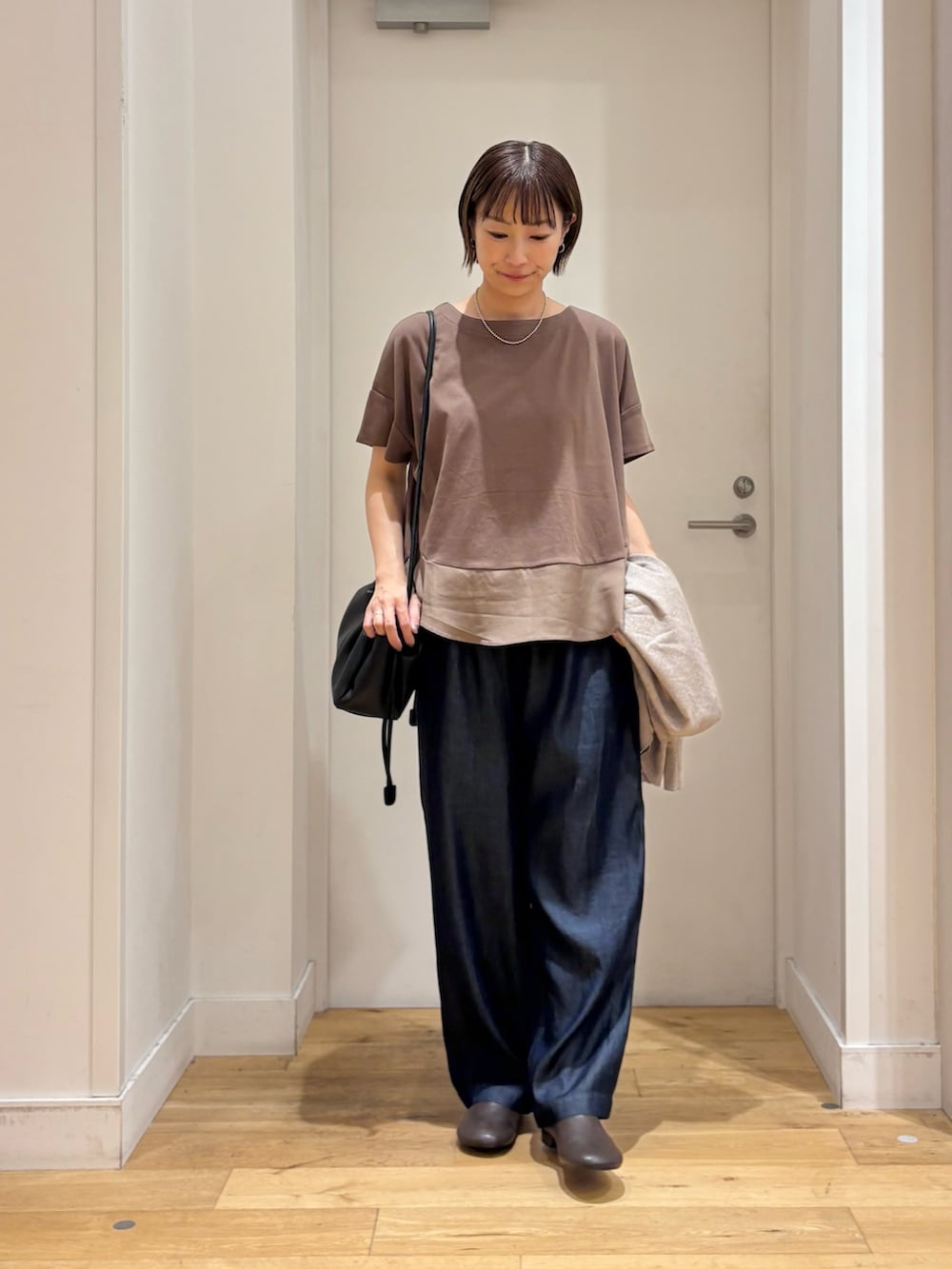 ブラウン系のTシャツ/カットソー、ブルー系のデニムパンツ、ベージュ系のカーディガン/ボレロを着用したレディースの夏コーディネートの5枚目の写真