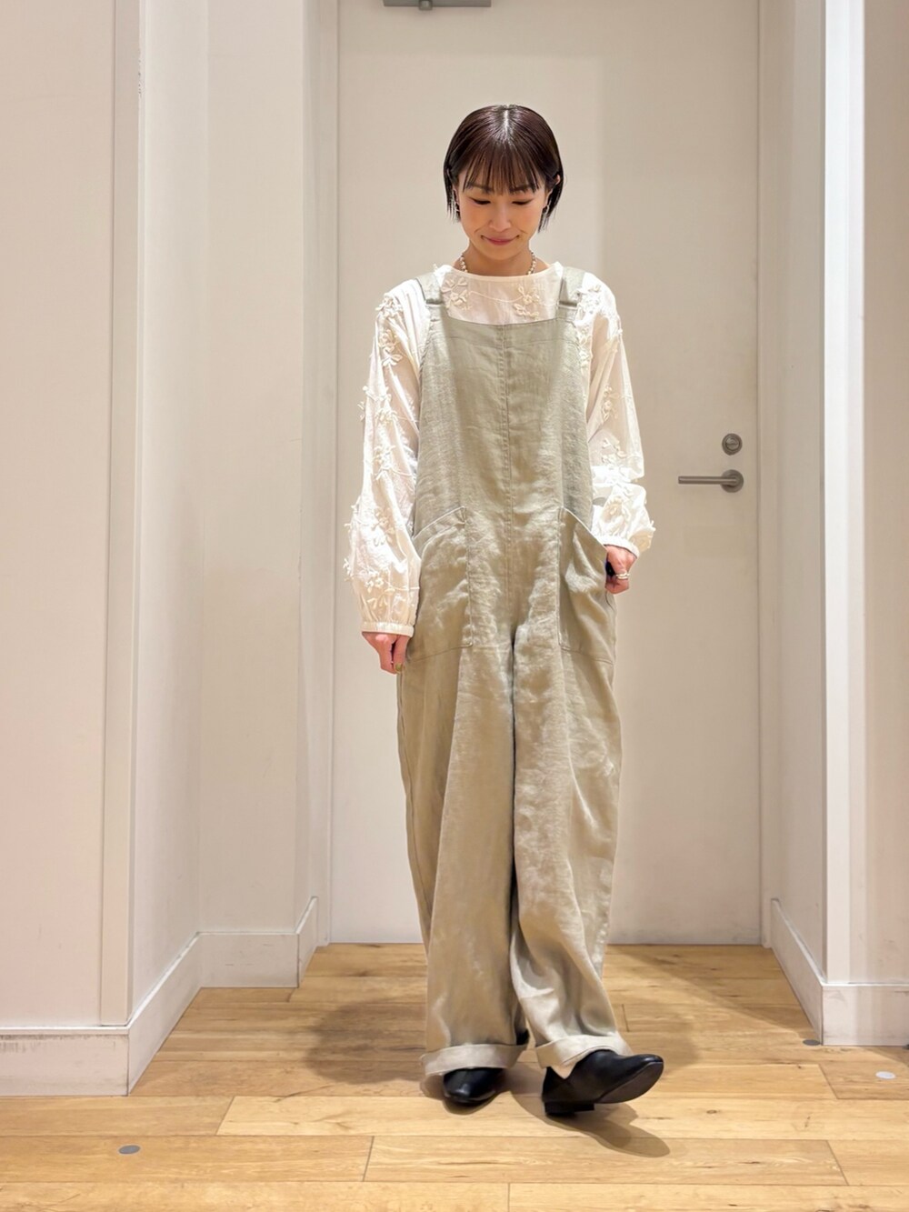 ホワイト系のシャツ/ブラウス、グレー系のサロペット/オーバーオール、ブラック系のその他シューズを着用したレディースの春コーディネートの7枚目の写真