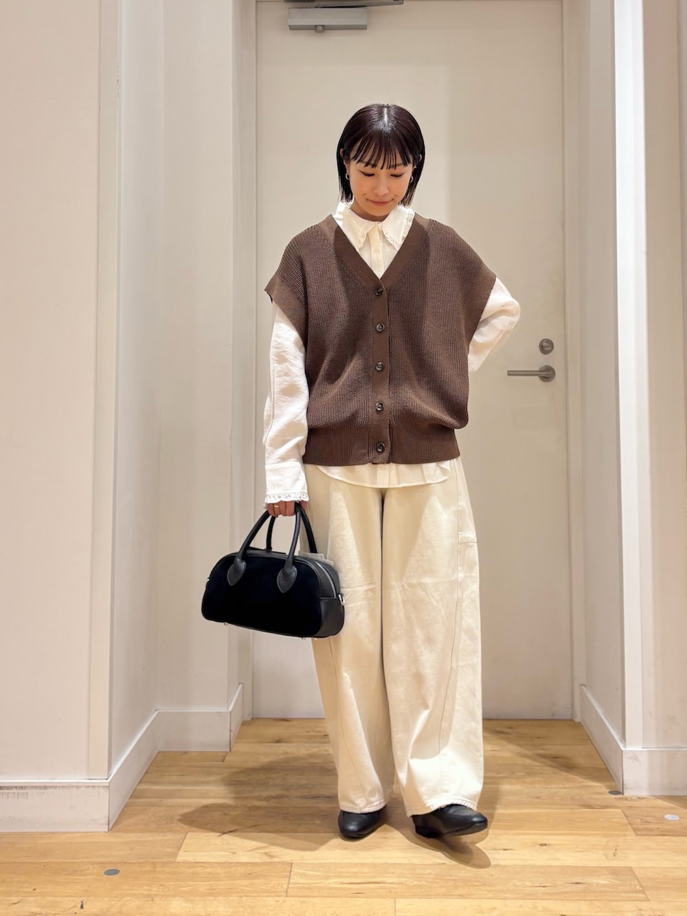 ブラウン系のベスト、ホワイト系のその他パンツ、ホワイト系のシャツ/ブラウスを着用したレディースの秋コーディネートの3枚目の写真