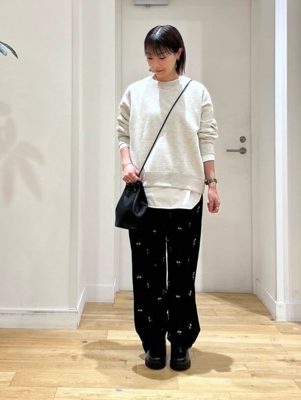 ベージュ系のスウェット、ブラック系のショルダーバッグ、ホワイト系のTシャツ/カットソーを着用したレディースの秋コーディネートの3枚目の写真
