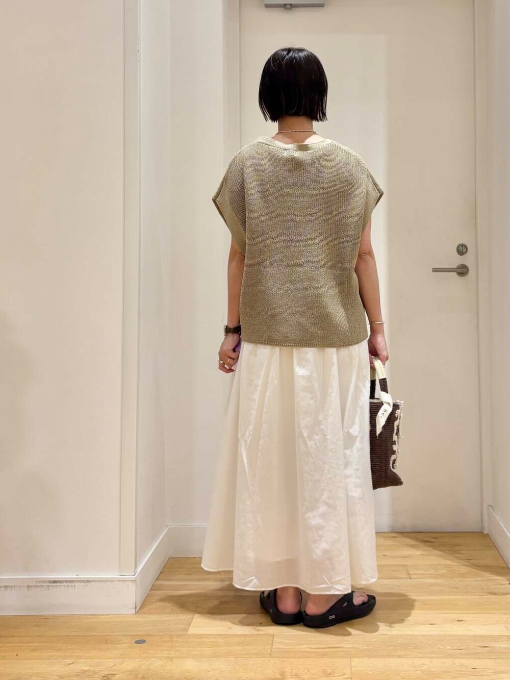 ブラック系のサンダル、ブラウン系のショルダーバッグ、ホワイト系のワンピースを着用したレディースの夏コーディネートの5枚目の写真