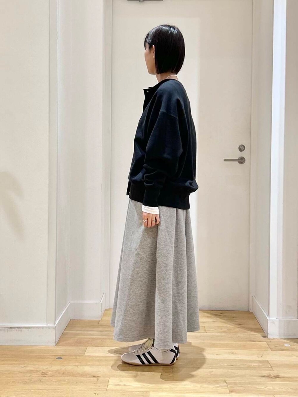 ホワイト系のTシャツ/カットソー、グレー系のスカート、ホワイト系のスニーカーを着用したレディースの冬コーディネートの4枚目の写真