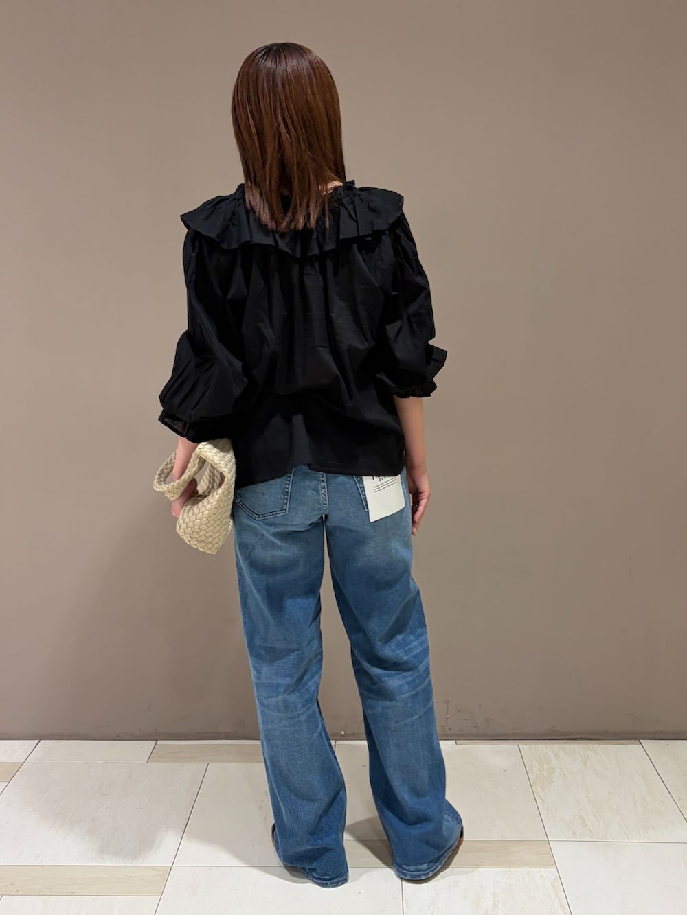 ブルー系のデニムパンツ、ブラック系のシャツ/ブラウス、ベージュ系のトートバッグを着用したレディースの夏コーディネートの3枚目の写真