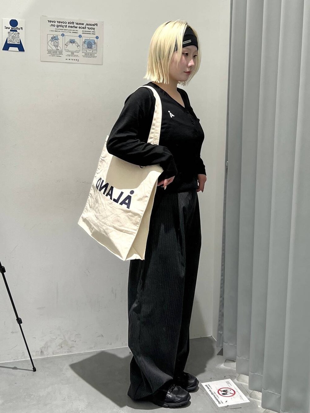 ブラック系のスラックス、その他のトートバッグ、ブラック系のヘアバンドを着用したレディースの秋コーディネートの4枚目の写真