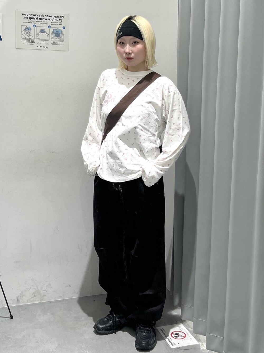 ブラウン系のトートバッグ、ブラック系のカーゴパンツ、ブラック系のヘアバンドを着用したレディースの秋コーディネートの4枚目の写真