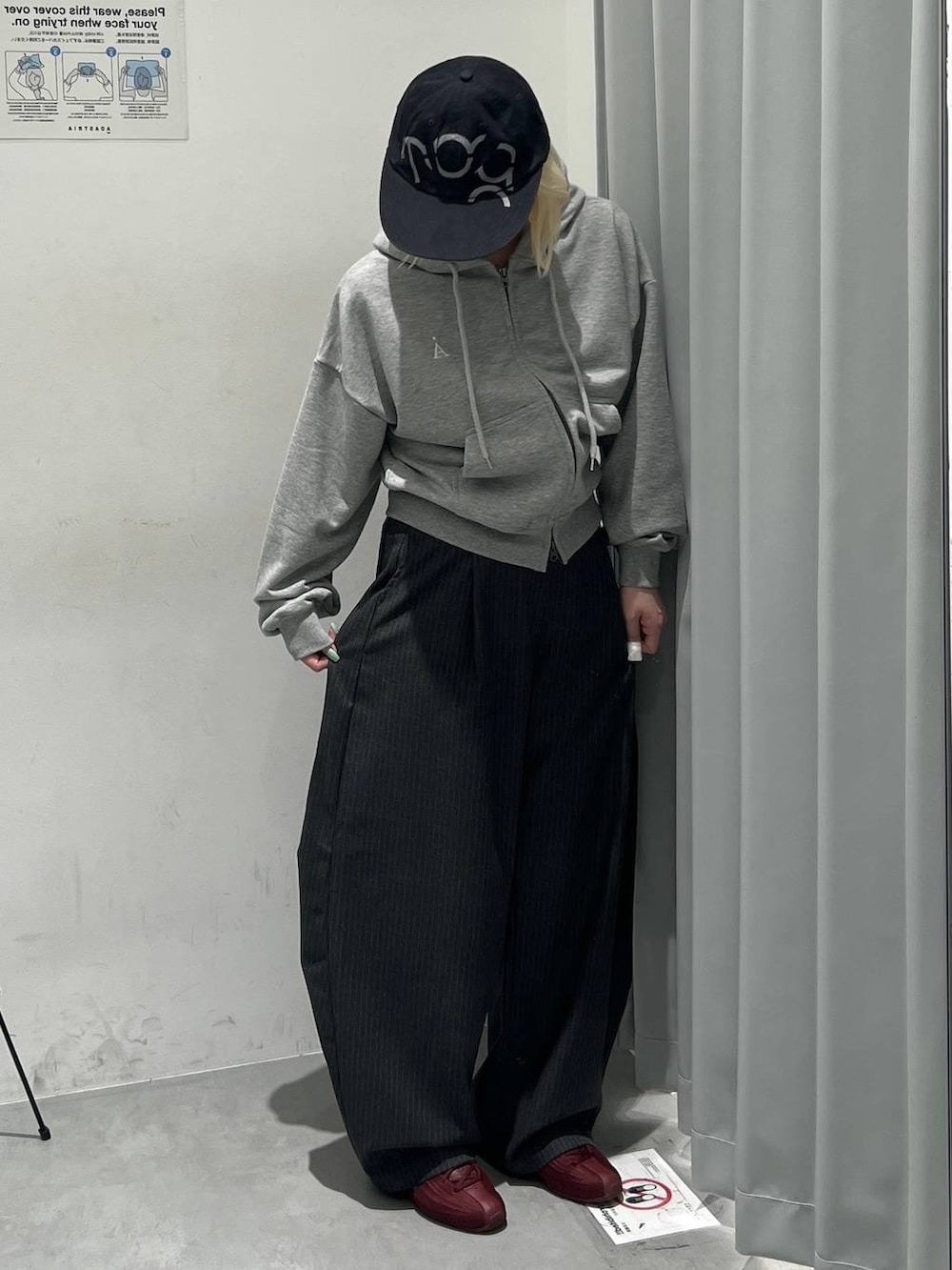 ブラック系のスラックス、グレー系のパーカー、ブラック系のキャップを着用したレディースの秋コーディネートの4枚目の写真