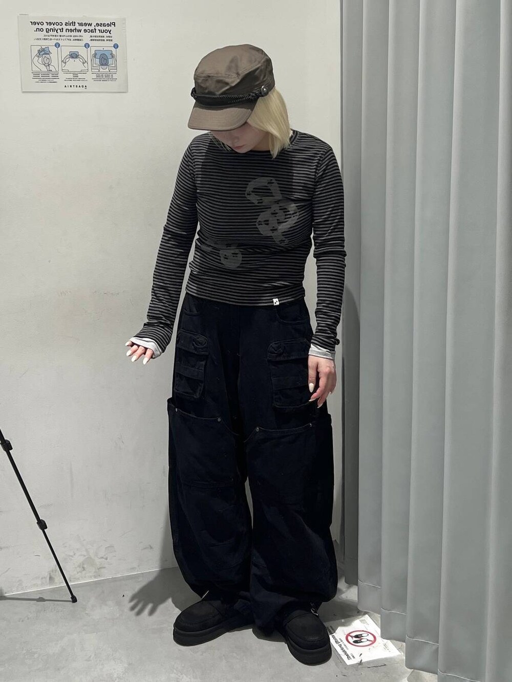 ブラック系のカーゴパンツ、ブラック系のTシャツ/カットソー、グリーン系のキャスケットを着用したレディースの秋コーディネートの2枚目の写真