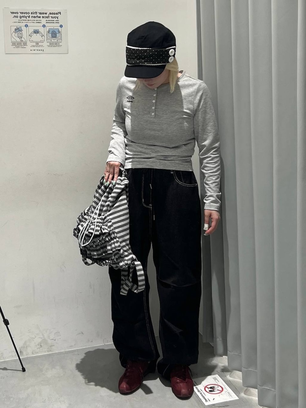 グレー系のTシャツ/カットソー、グレー系のバックパック/リュック、ブラック系のデニムパンツを着用したレディースの秋コーディネートの4枚目の写真