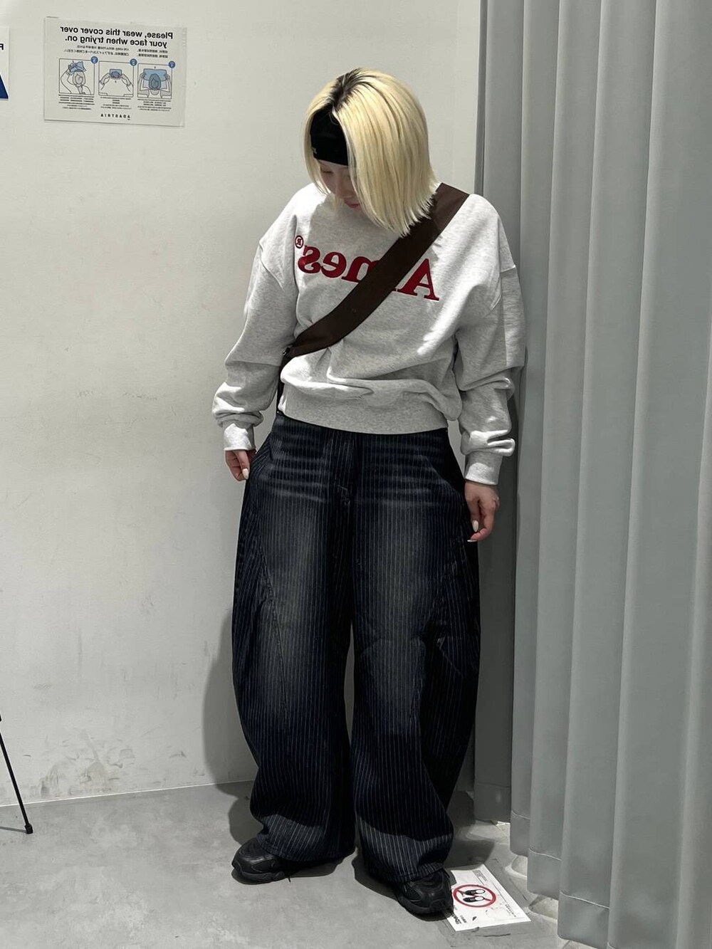 ブラウン系のトートバッグ、ブラック系のデニムパンツを着用したレディースの秋コーディネートの3枚目の写真