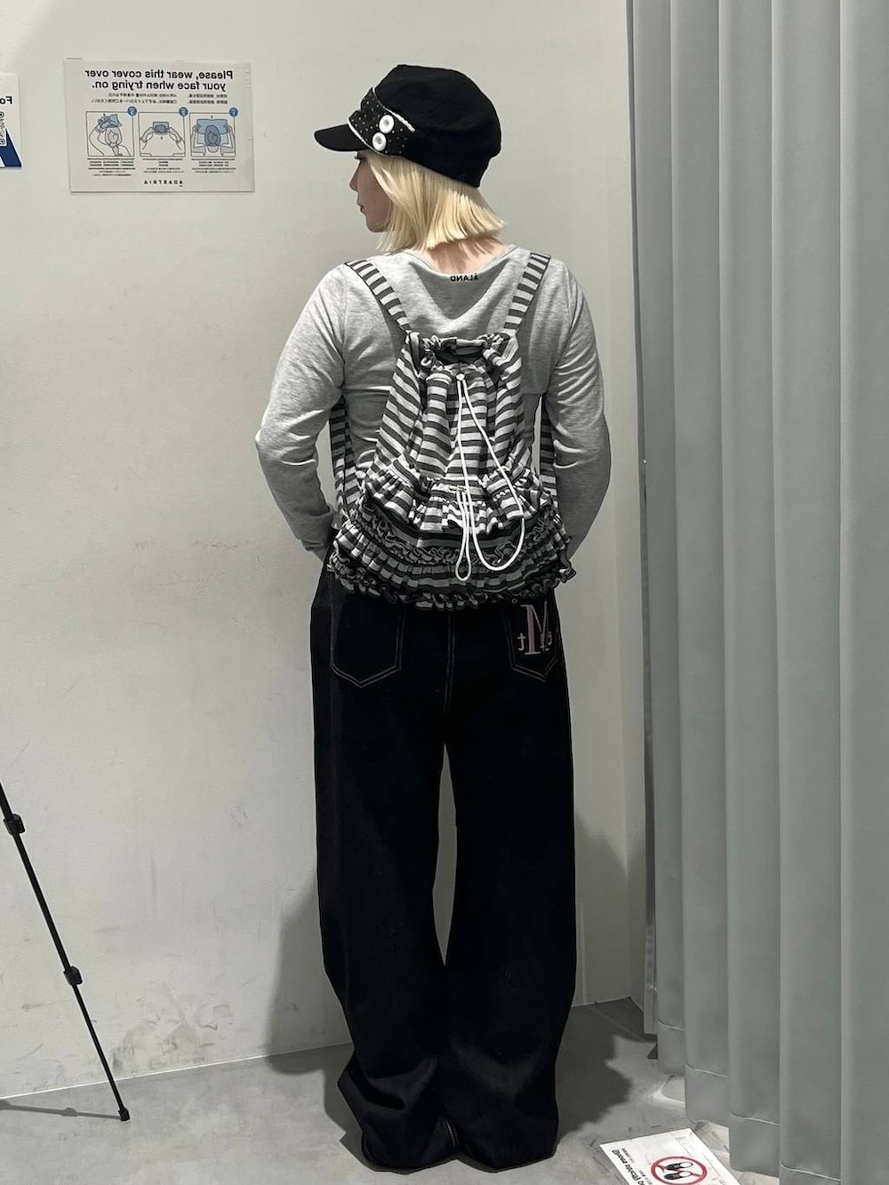 グレー系のTシャツ/カットソー、グレー系のバックパック/リュック、ブラック系のデニムパンツを着用したレディースの秋コーディネートの3枚目の写真