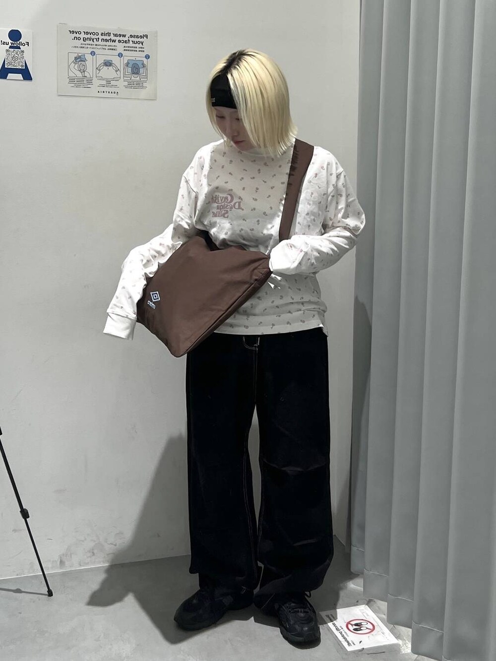 ブラウン系のトートバッグ、ブラック系のカーゴパンツ、ブラック系のヘアバンドを着用したレディースの秋コーディネートの2枚目の写真