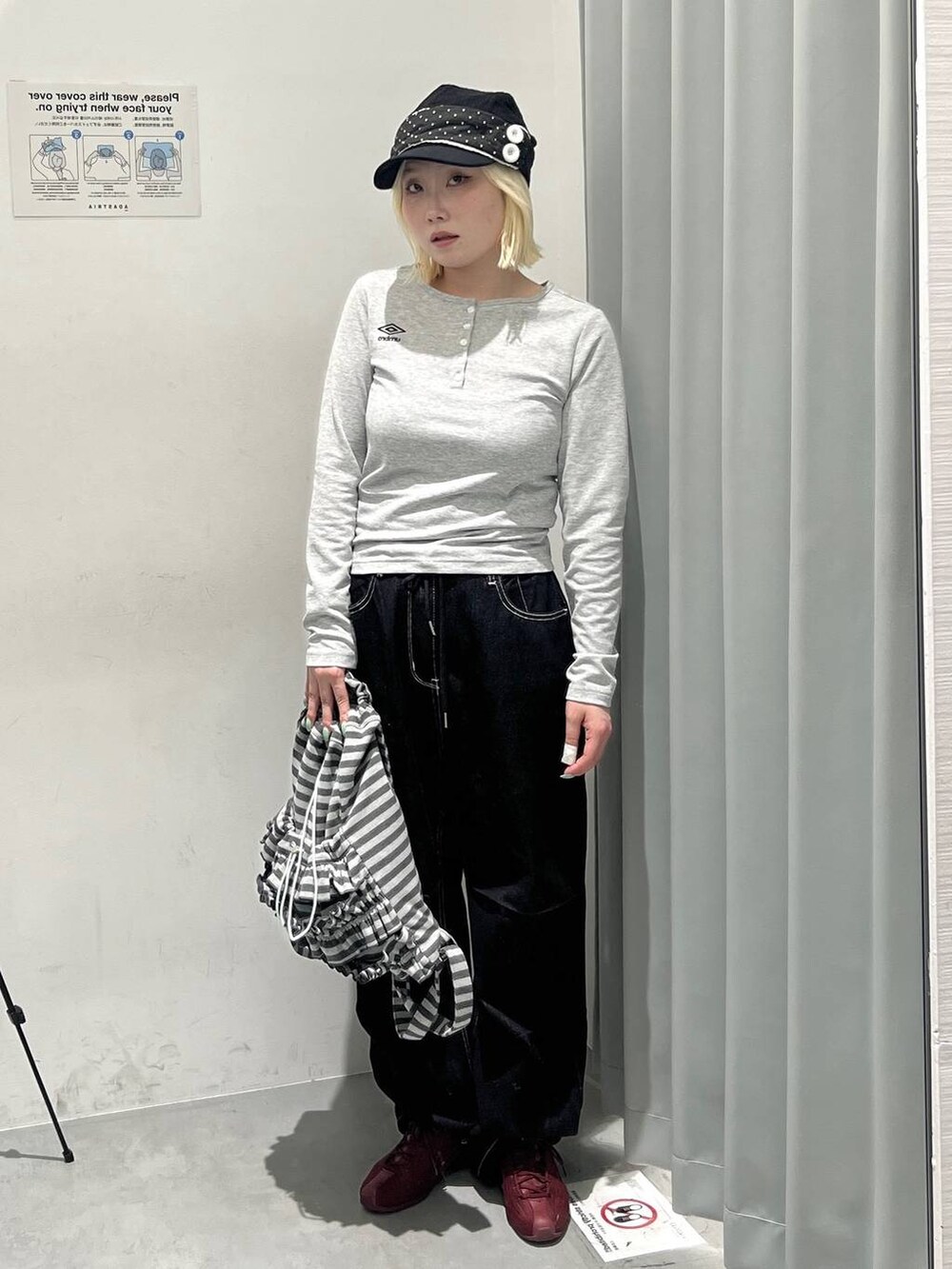 グレー系のTシャツ/カットソー、グレー系のバックパック/リュック、ブラック系のデニムパンツを着用したレディースの秋コーディネートの2枚目の写真