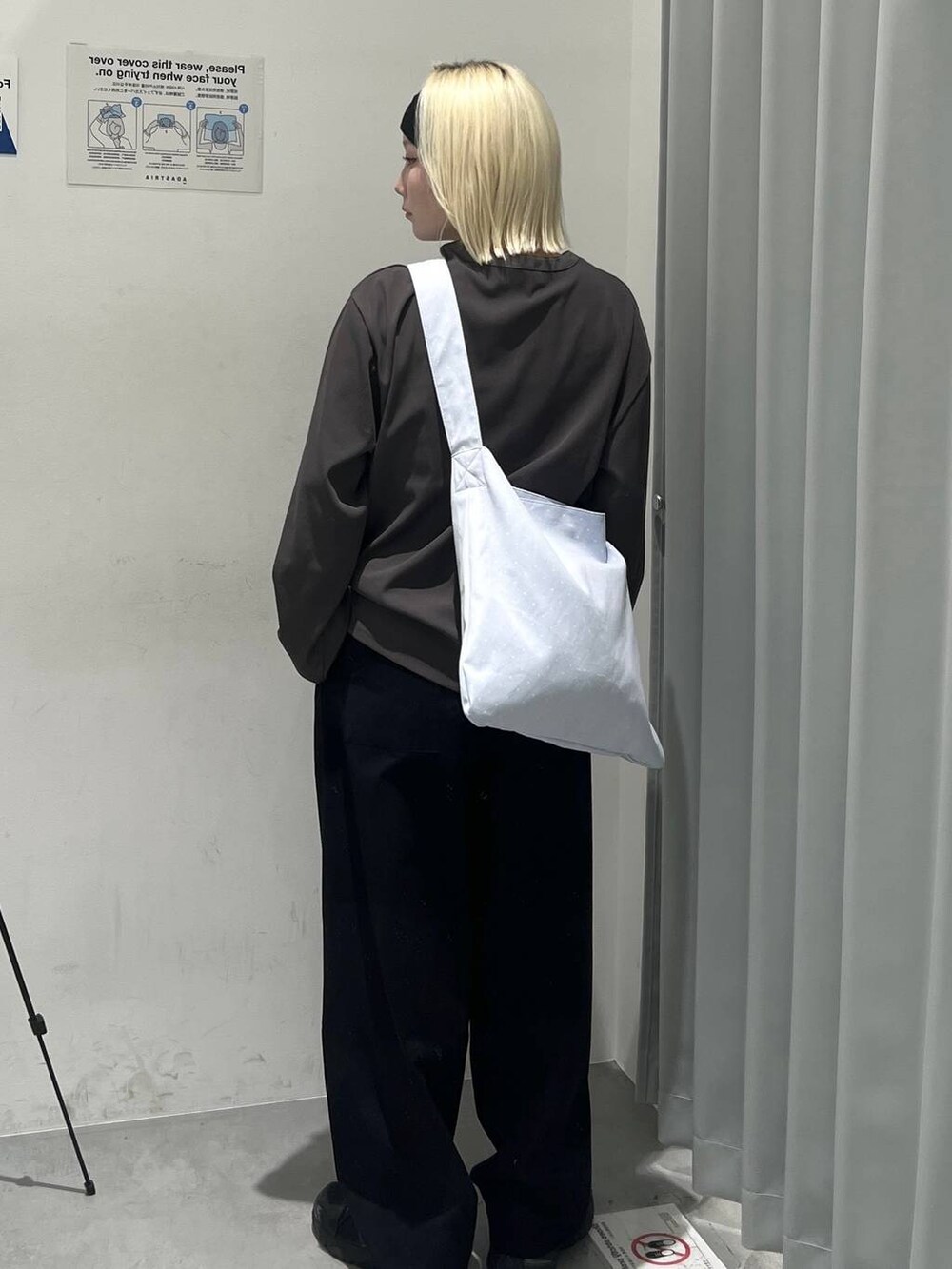 グレー系のTシャツ/カットソー、ブラック系のスラックス、ブルー系のトートバッグを着用したレディースの秋コーディネートの2枚目の写真