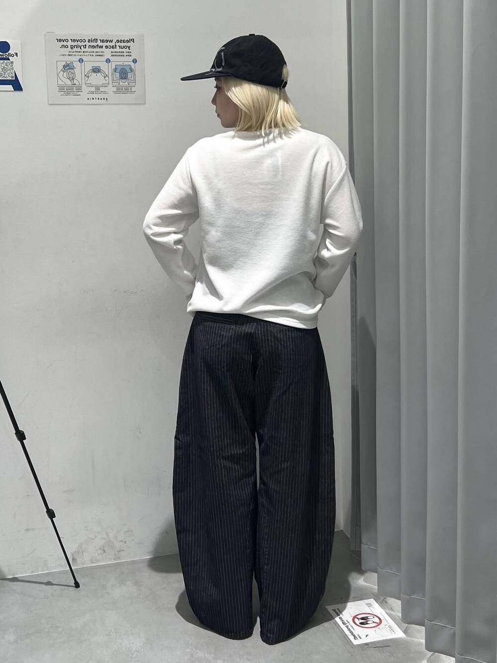 ホワイト系のTシャツ/カットソー、ブラック系のデニムパンツ、ブラック系のキャップを着用したレディースの秋コーディネートの2枚目の写真
