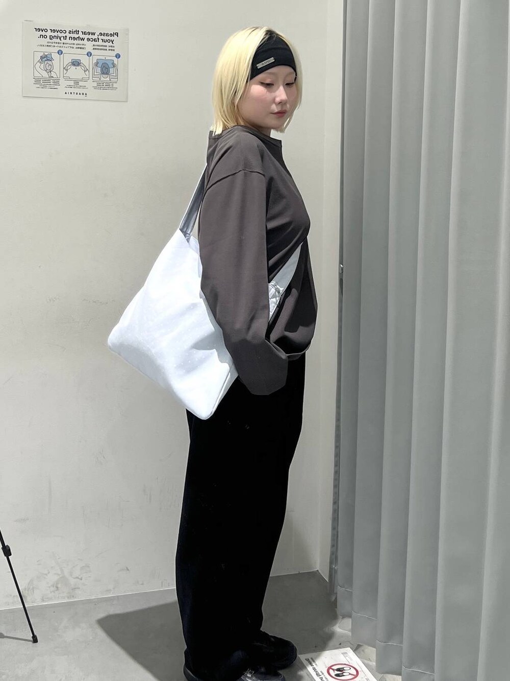 グレー系のTシャツ/カットソー、ブラック系のスラックス、ブルー系のトートバッグを着用したレディースの秋コーディネートの4枚目の写真