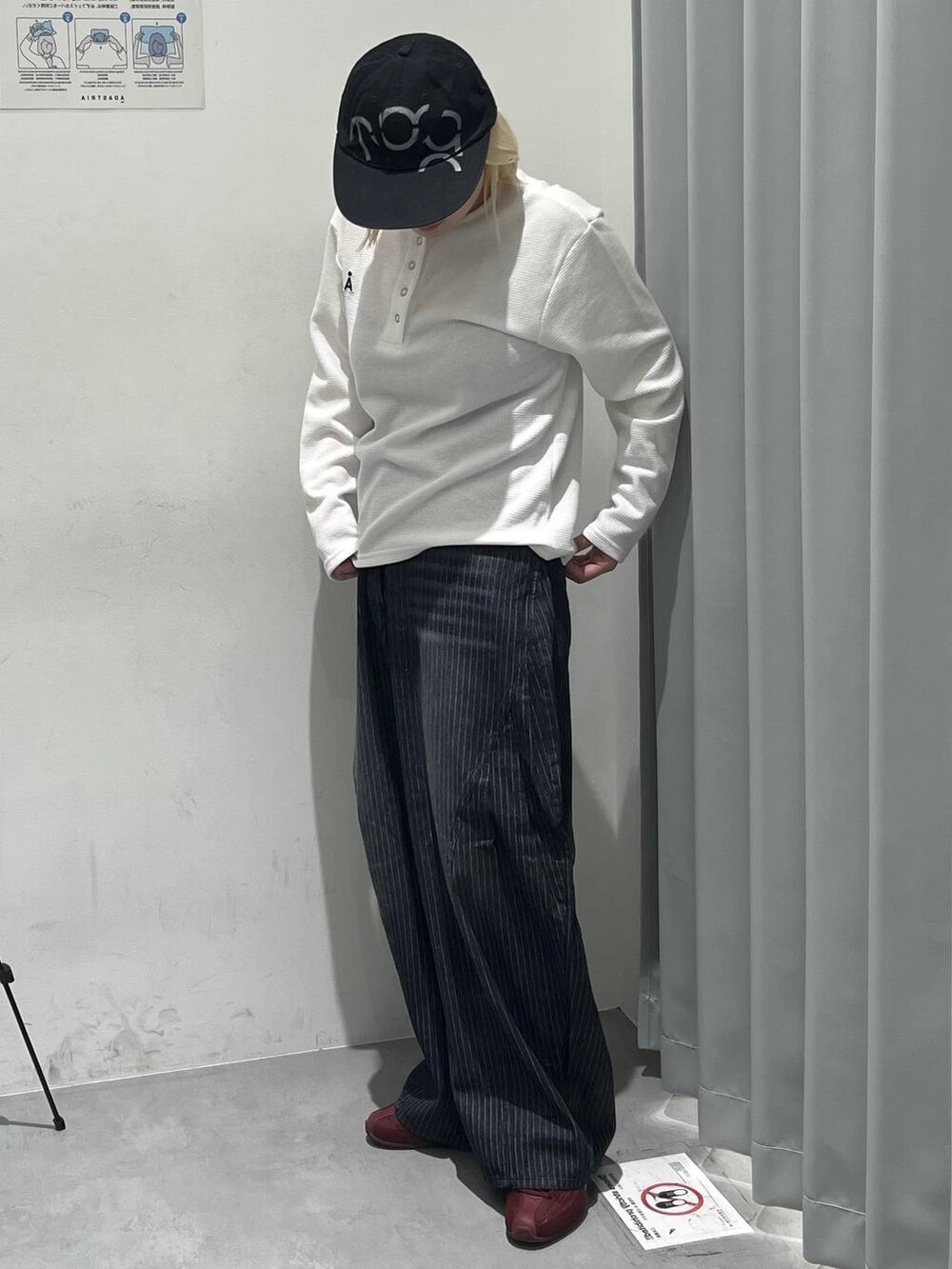 ホワイト系のTシャツ/カットソー、ブラック系のデニムパンツ、ブラック系のキャップを着用したレディースの秋コーディネートの4枚目の写真