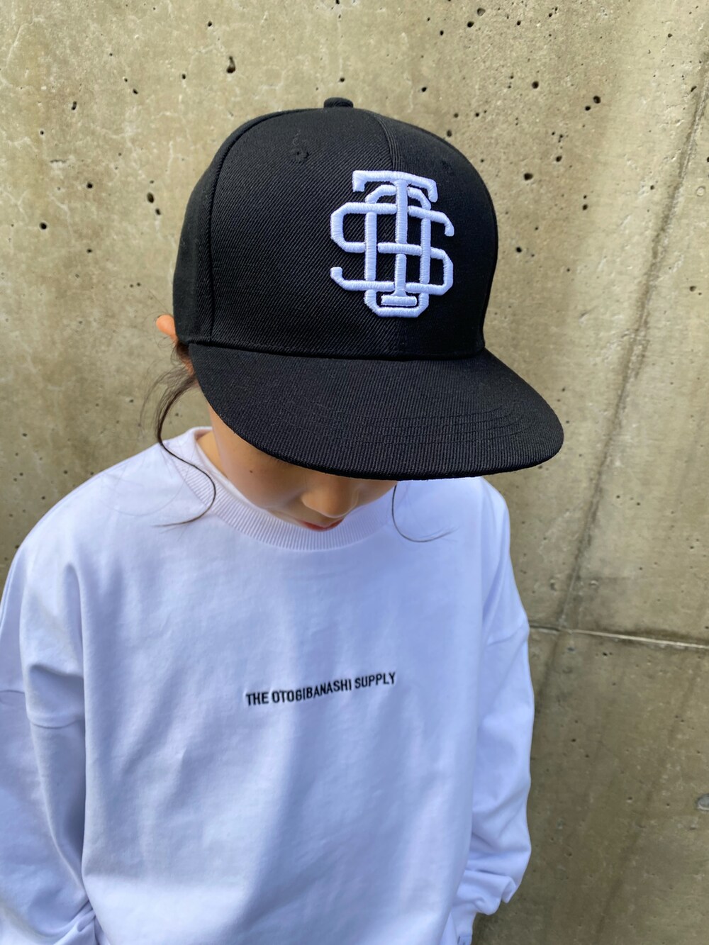 グレー系のスラックス、ブラック系のスリッポン、ホワイト系のTシャツ/カットソーを着用したキッズの冬コーディネートの3枚目の写真