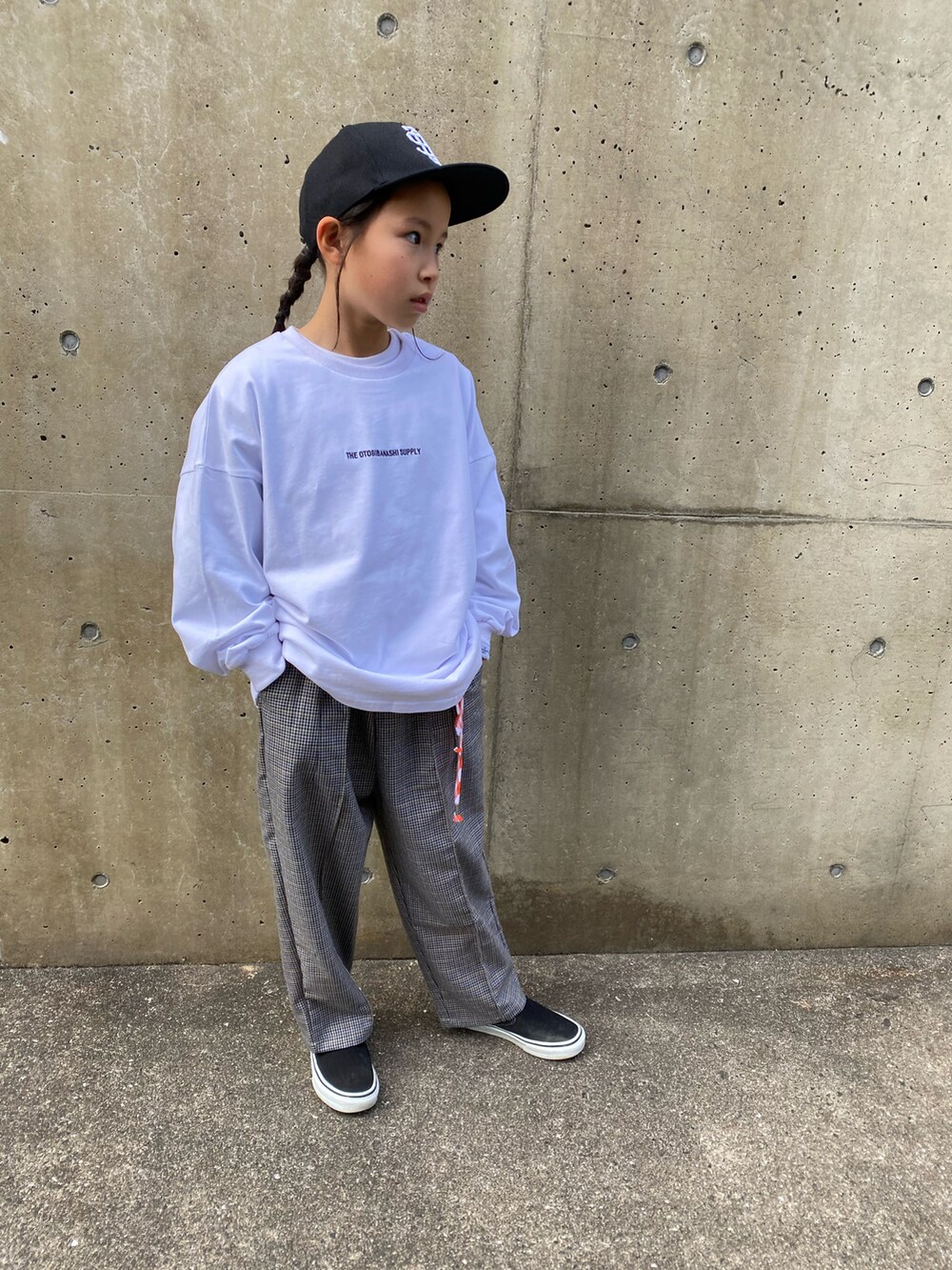 グレー系のスラックス、ブラック系のスリッポン、ホワイト系のTシャツ/カットソーを着用したキッズの冬コーディネートの2枚目の写真