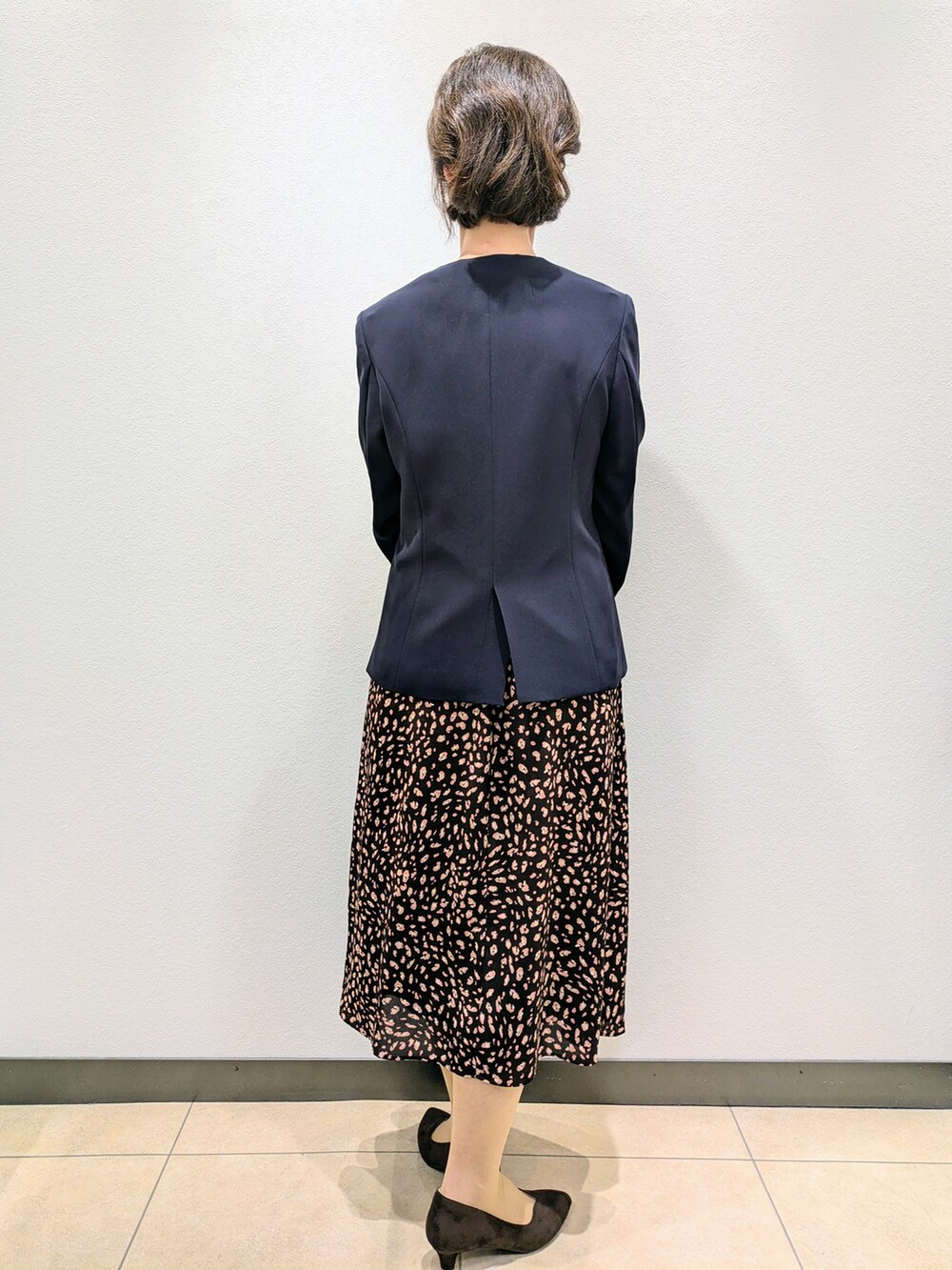 ブルー系のノーカラージャケット、ブラウン系のワンピース、ブラウン系のトートバッグを着用したレディースの夏コーディネートの2枚目の写真