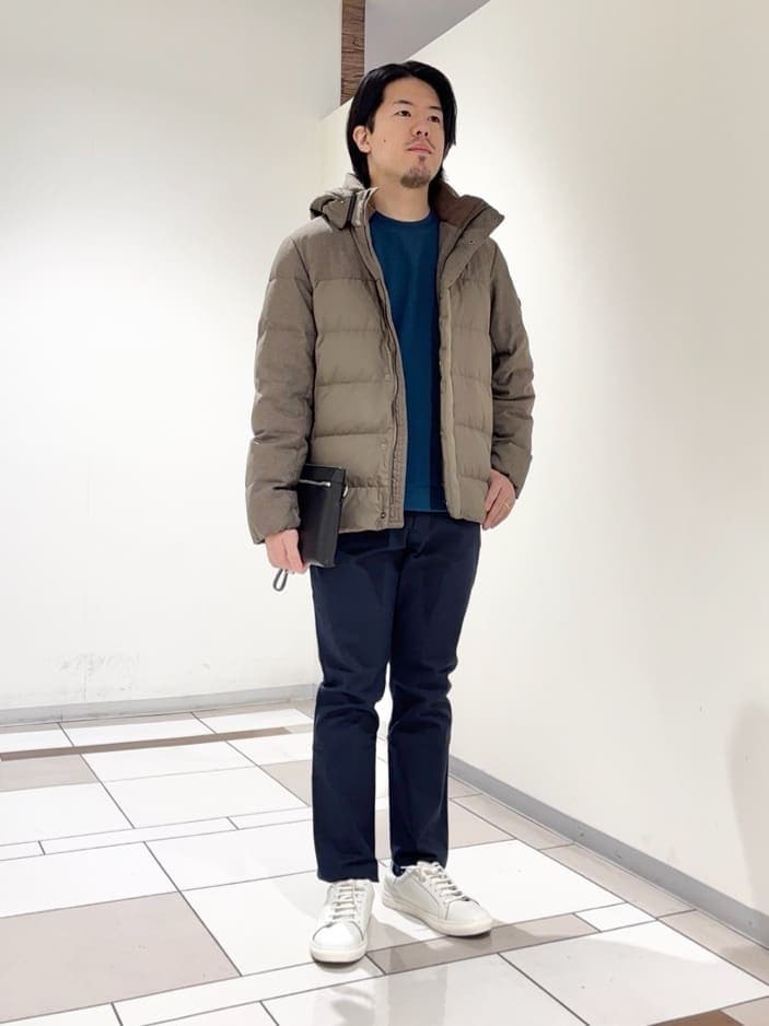ブラウン系のダウンジャケット/コート、ブルー系のTシャツ/カットソー、ブルー系のスラックスを着用したメンズの冬コーディネートの3枚目の写真