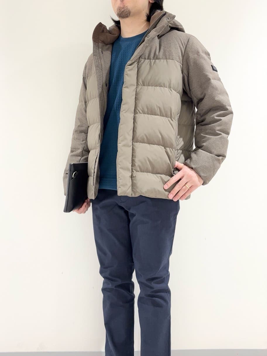 ブラウン系のダウンジャケット/コート、ブルー系のTシャツ/カットソー、ブルー系のスラックスを着用したメンズの冬コーディネートの6枚目の写真