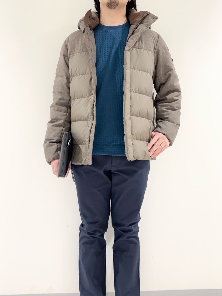 ブラウン系のダウンジャケット/コート、ブルー系のTシャツ/カットソー、ブルー系のスラックスを着用したメンズの冬コーディネートの5枚目の写真