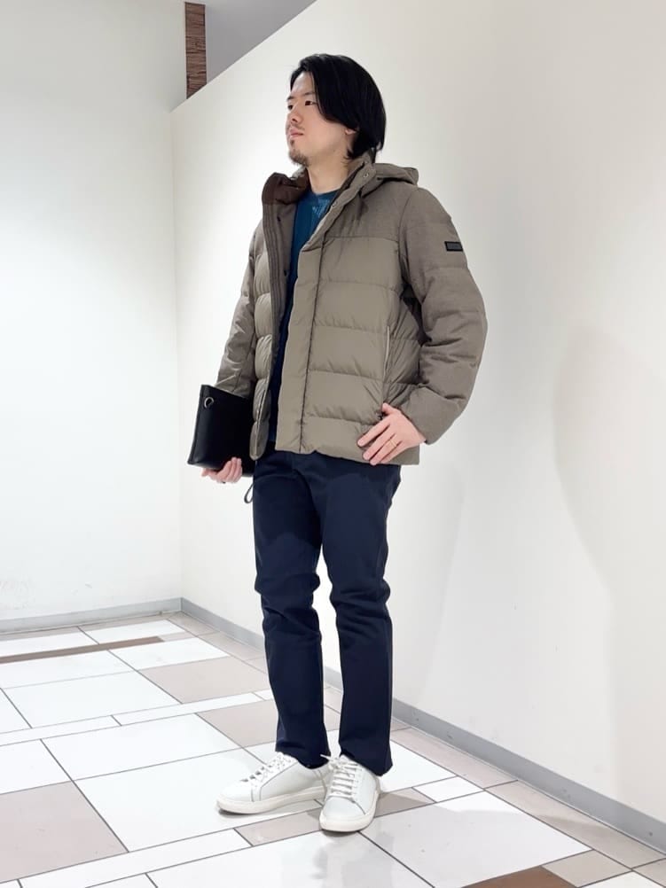 ブラウン系のダウンジャケット/コート、ブルー系のTシャツ/カットソー、ブルー系のスラックスを着用したメンズの冬コーディネートの2枚目の写真