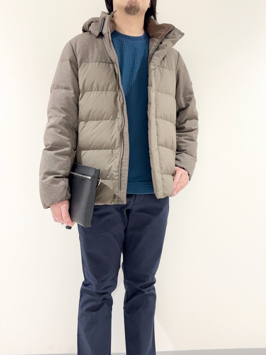 ブラウン系のダウンジャケット/コート、ブルー系のTシャツ/カットソー、ブルー系のスラックスを着用したメンズの冬コーディネートの7枚目の写真