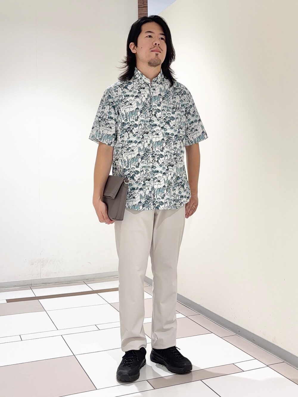 ブルー系のシャツ/ブラウス、ベージュ系のスラックス、グレー系のショルダーバッグを着用したメンズの夏コーディネートの2枚目の写真