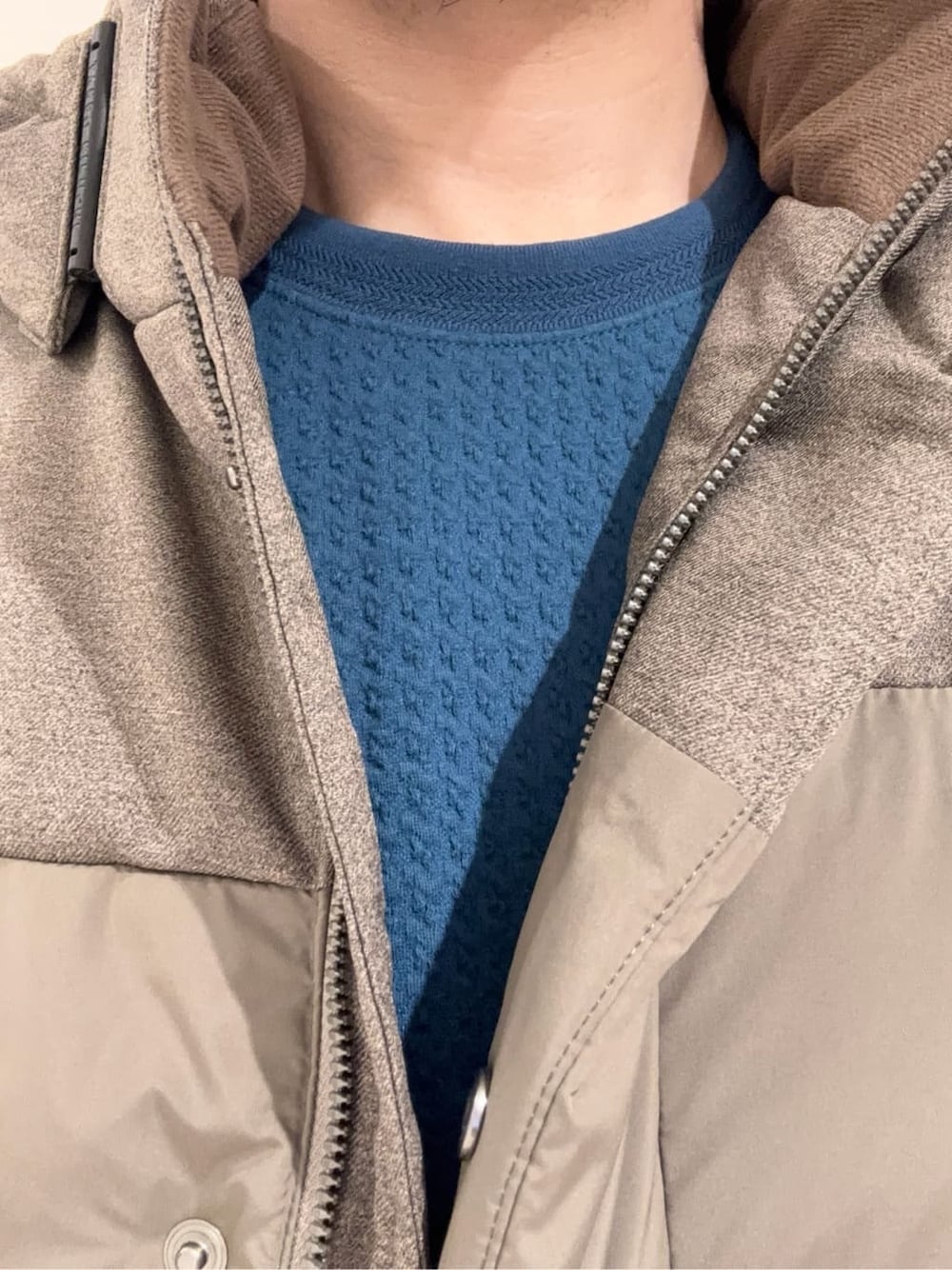 ブラウン系のダウンジャケット/コート、ブルー系のTシャツ/カットソー、ブルー系のスラックスを着用したメンズの冬コーディネートの9枚目の写真