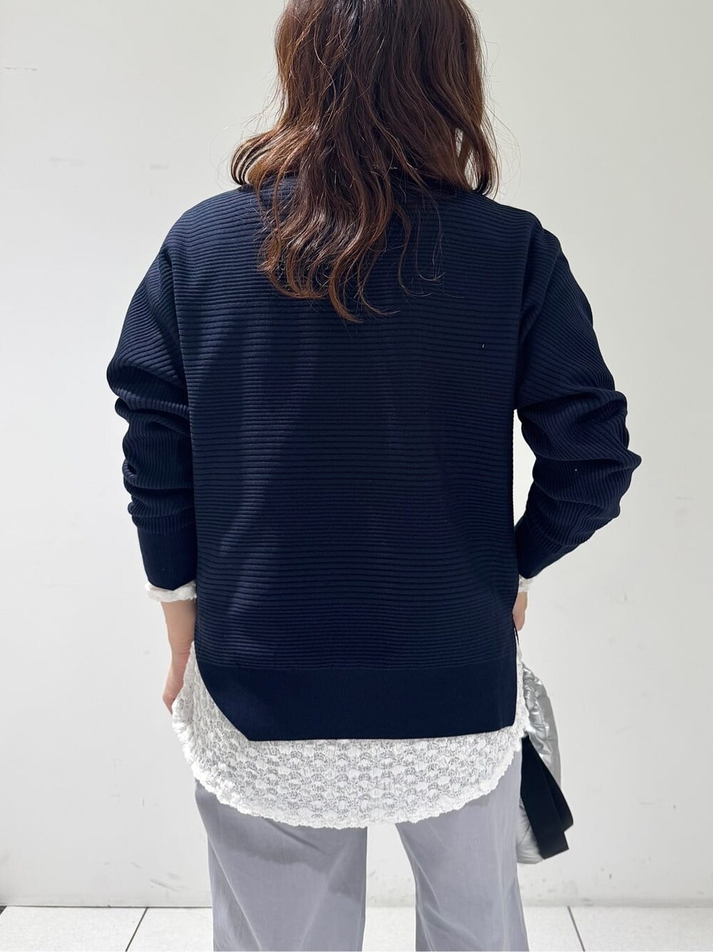 ブルー系のニット/セーター、ホワイト系のTシャツ/カットソー、グレー系のデニムパンツを着用したレディースの春コーディネートの7枚目の写真