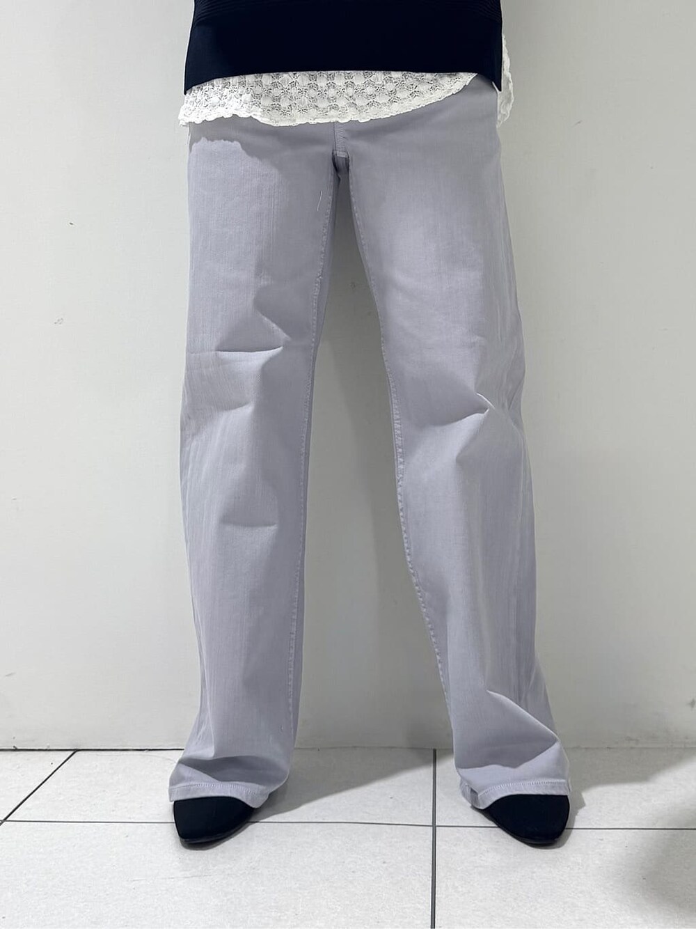 ブルー系のニット/セーター、ホワイト系のTシャツ/カットソー、グレー系のデニムパンツを着用したレディースの春コーディネートの9枚目の写真