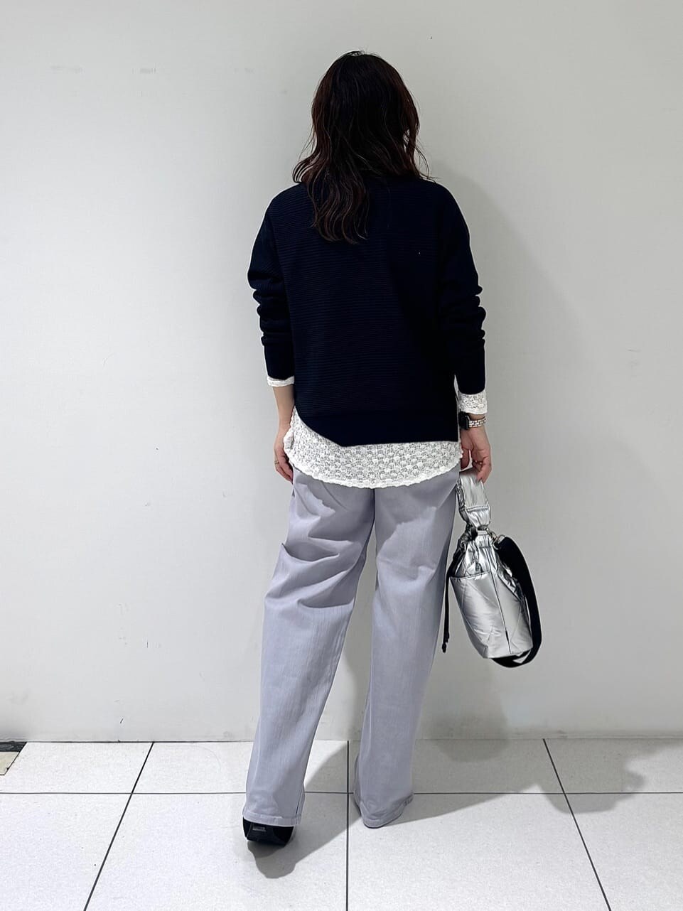 ブルー系のニット/セーター、ホワイト系のTシャツ/カットソー、グレー系のデニムパンツを着用したレディースの春コーディネートの4枚目の写真
