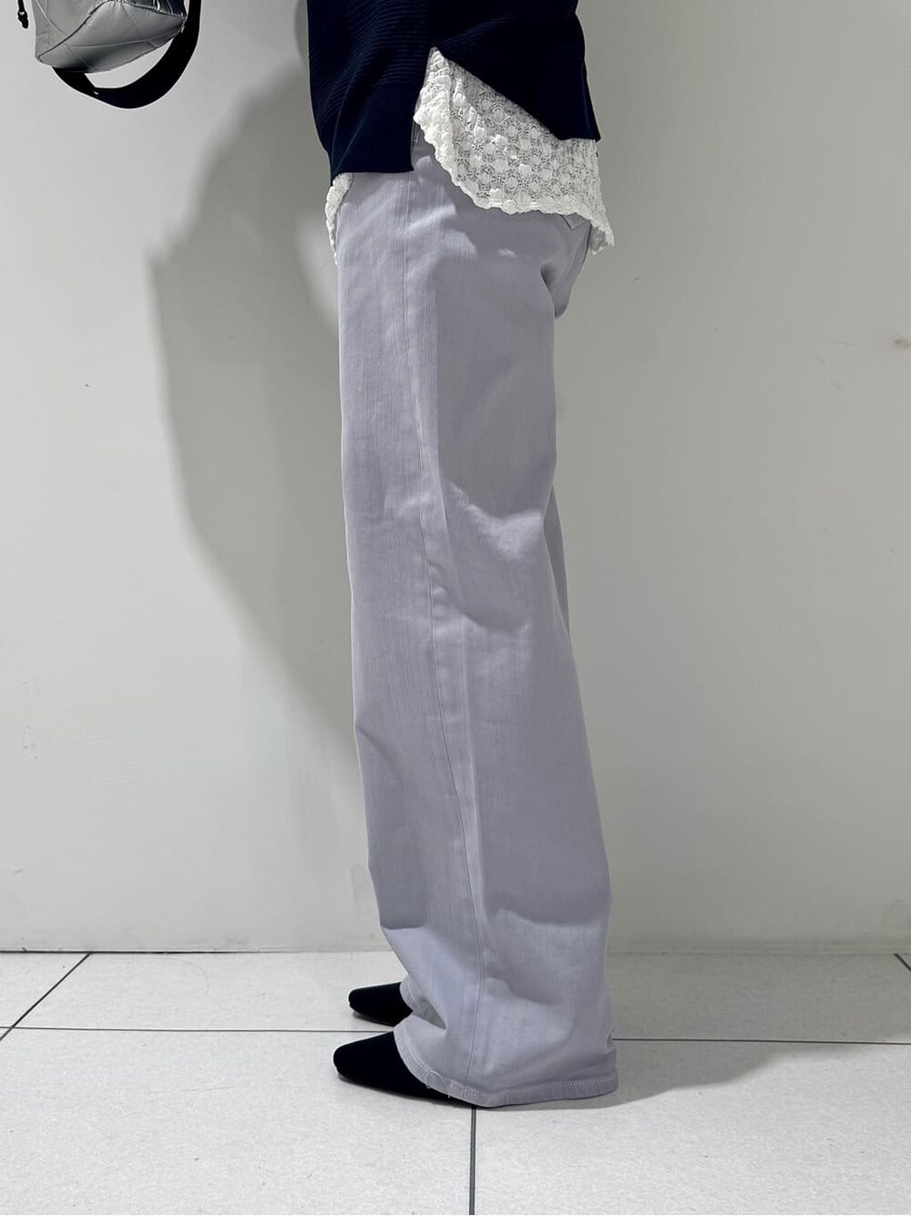 ブルー系のニット/セーター、ホワイト系のTシャツ/カットソー、グレー系のデニムパンツを着用したレディースの春コーディネートの10枚目の写真