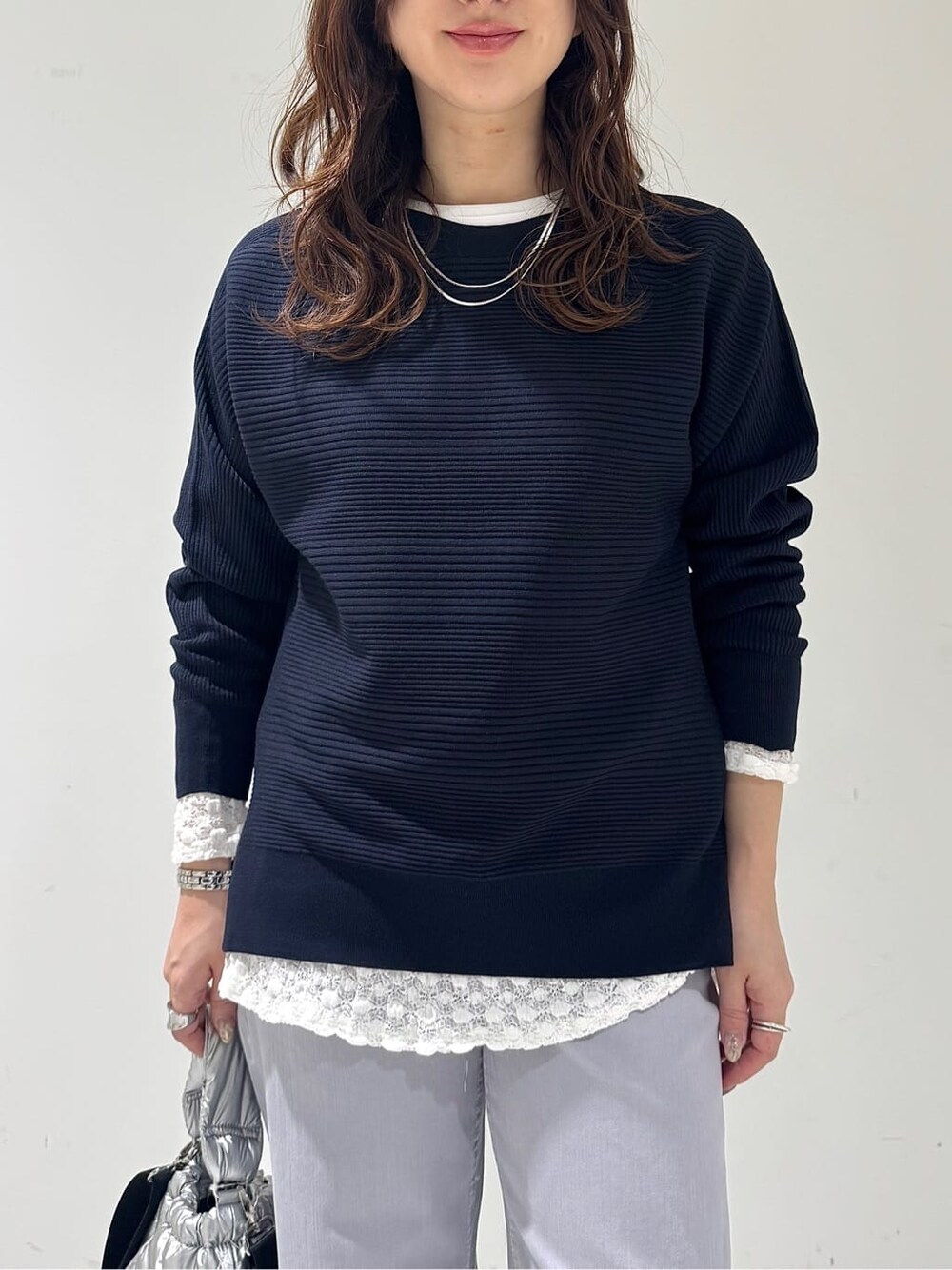 ブルー系のニット/セーター、ホワイト系のTシャツ/カットソー、グレー系のデニムパンツを着用したレディースの春コーディネートの5枚目の写真