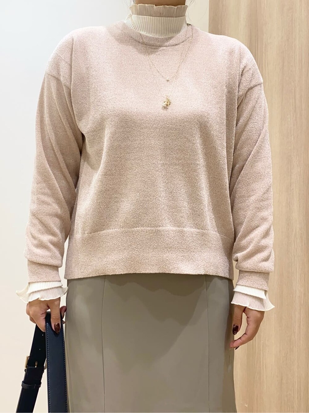 ピンク系のニット/セーター、ホワイト系のニット/セーター、ベージュ系のスカートを着用したレディースの秋コーディネートの4枚目の写真